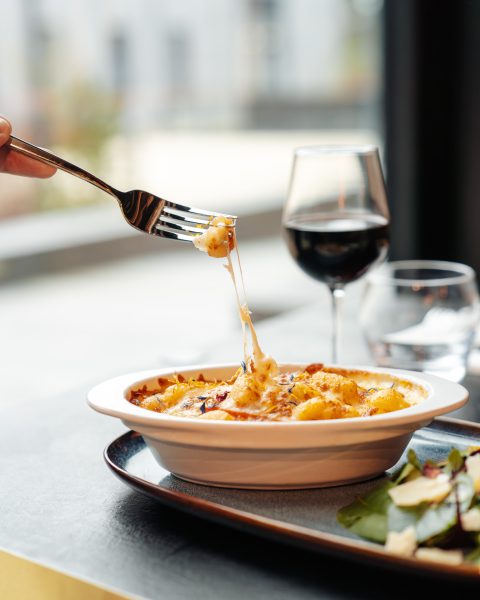 un client qui déguste son plat de pâtes avec un verre de vin Osteria Lume