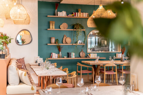 Salle de restaurant avec étagères et décor vert